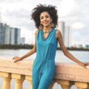 Woman in blue romper resting against railing